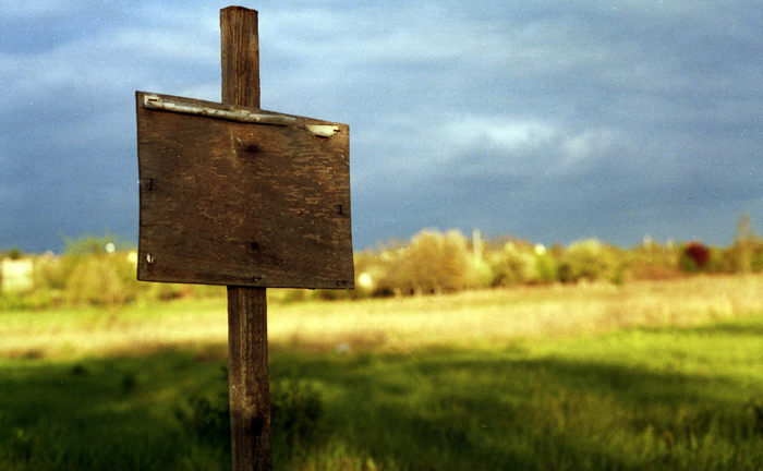 Пустая табличка на бесхозном земельном участке.