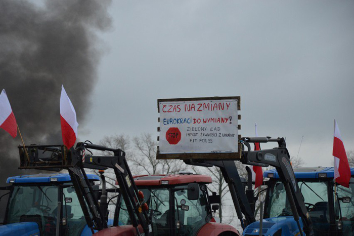 Трактор поднял на своей стреле плакат с требованиями польских протестующих.