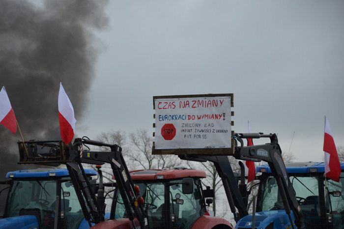 Плакат з вимогами польських фермерів вивішений на стрілі трактора. 