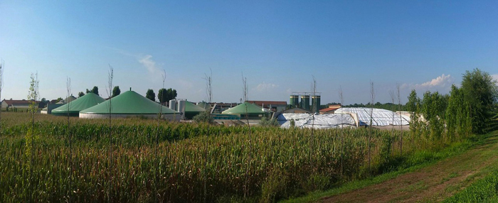Биогазовая установка и поле сельскохозяйственных культур.