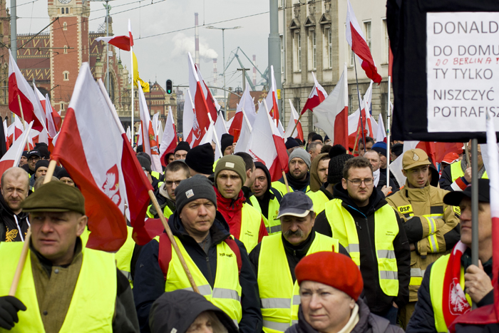 Коолонна участников протеста фермеров, одетых в желтые жилеты, с государственными флагами Польши в центре Гданьска. 