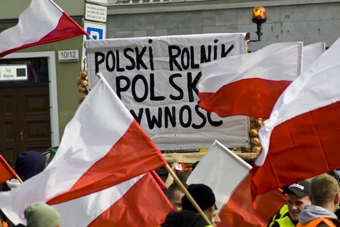 Державні прапори Польщі й банер з написом «Польський фермер – польська їжа».