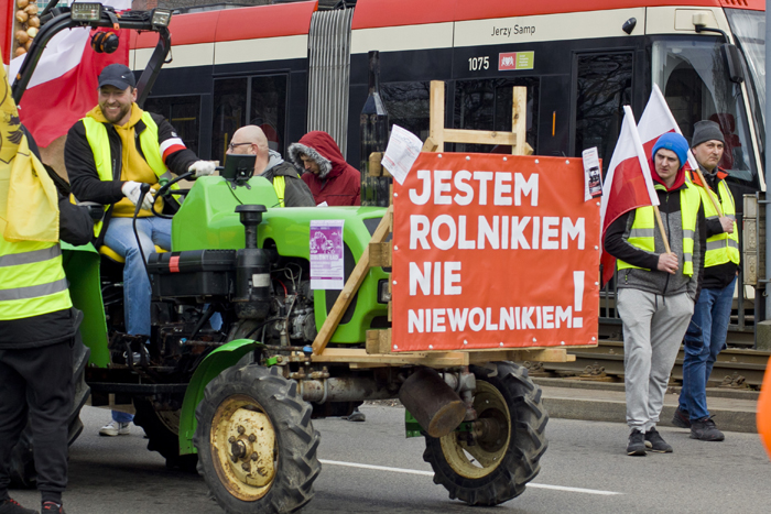 Фермер їде на тракторі з плакатом «Я фермер, а не невільник» під час протесту в Гданську.