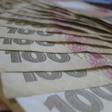 Несколько банкнот номиналом 100 украинских гривен.