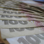 Кілька банкнот номіналом 100 українських гривень.